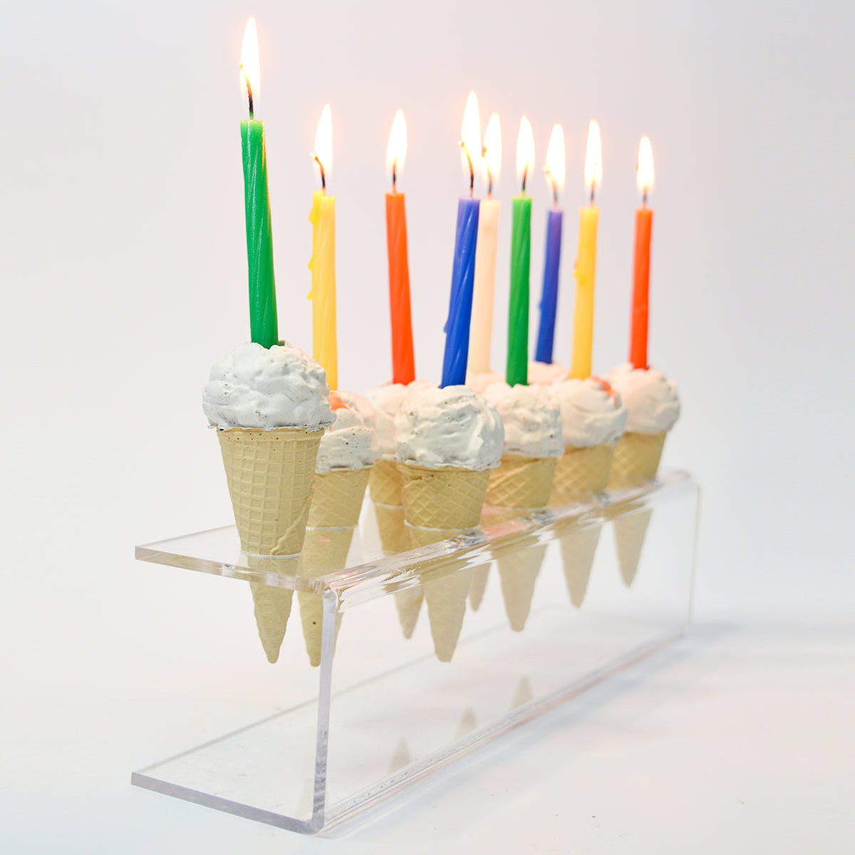 חנוכיית גלידה עם נרות צבעוניים, מבט מהצד על מעמד הפרספקס.